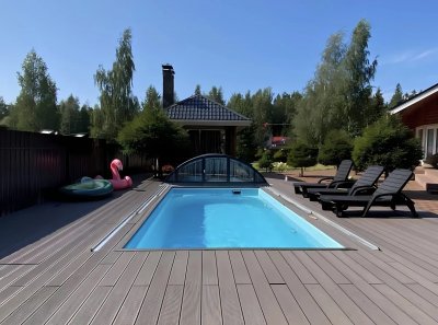 Прямоугольный бассейн на террасе с серой композитной доской и черными шезлонгами